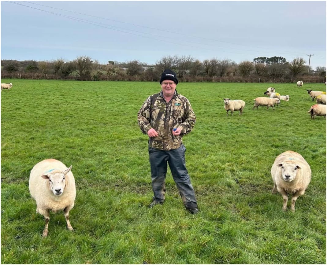 Geoff Henwood patting a sheep on the head